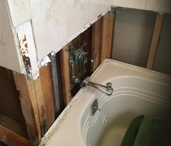 removed walls, showing plumbing by bathtub