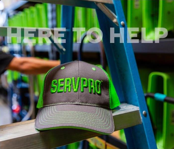 SERVPRO hat on a ladder in front of water damage equipment